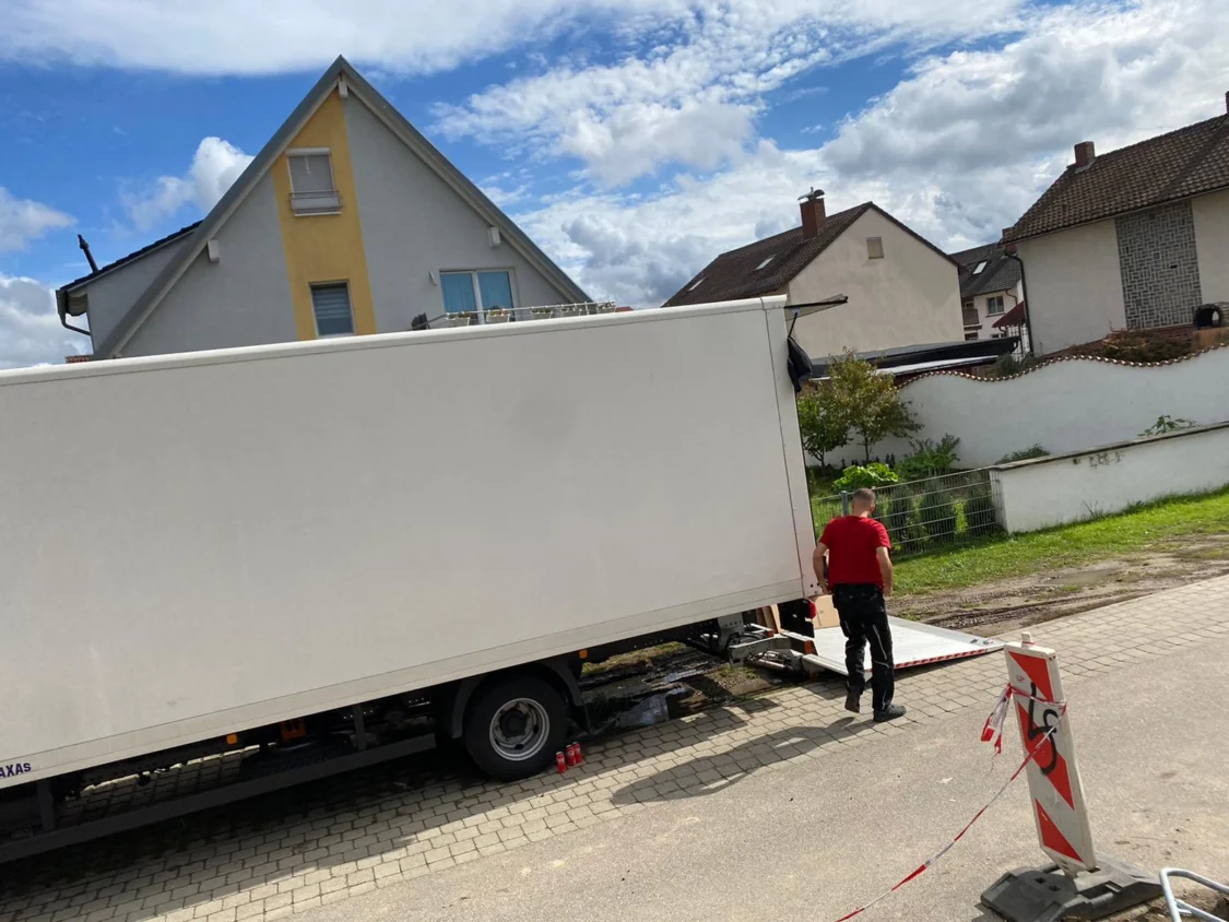 Umzugswagen von Sehic Umzüge mit ausgefahrener Rampe vor dem Haus beim Fernumzug