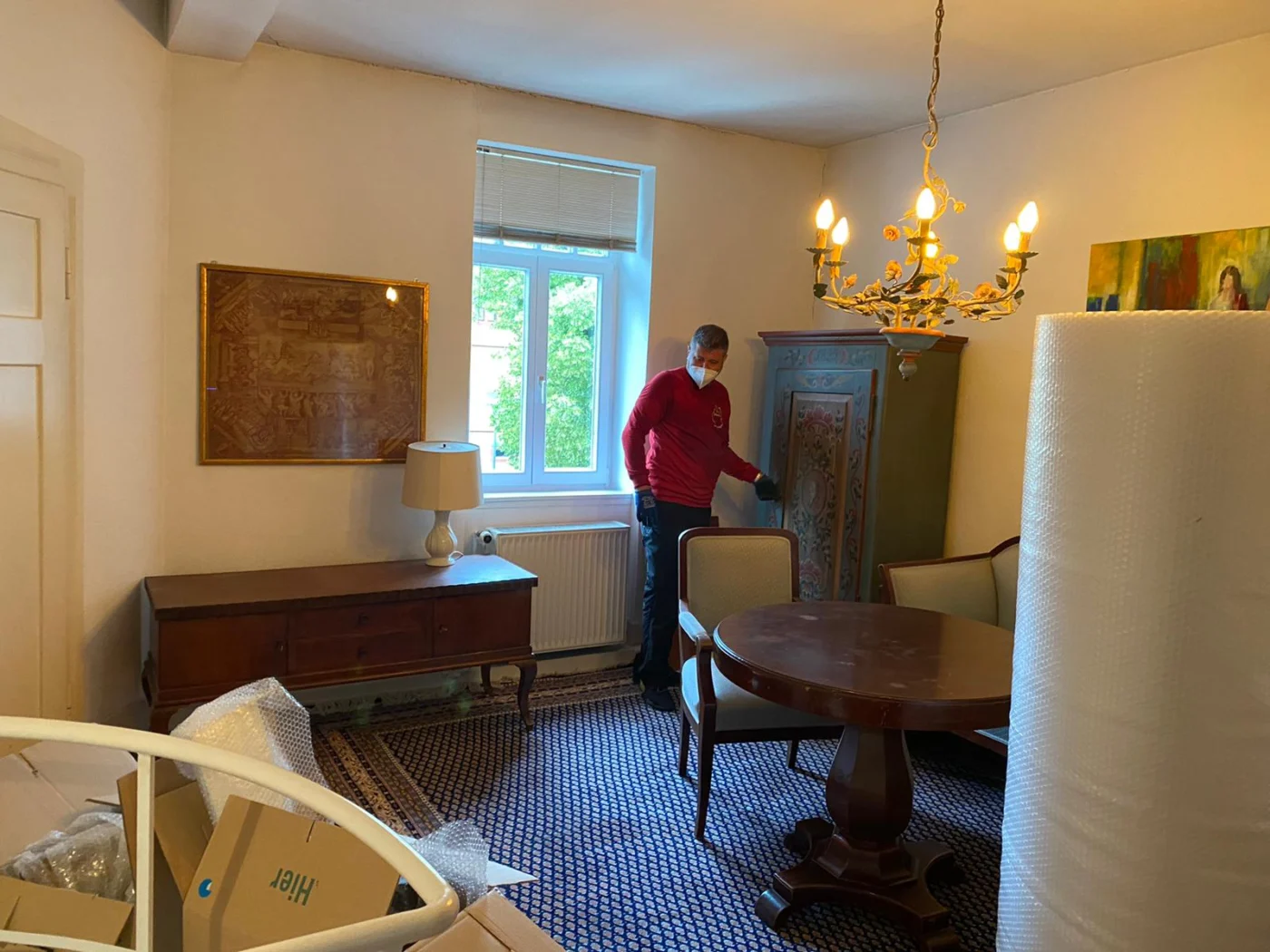 Klassisch eingerichtetes Wohnzimmer wird für den Seniorenumzug in Karlsruhe abgedeckt und vorbereitet